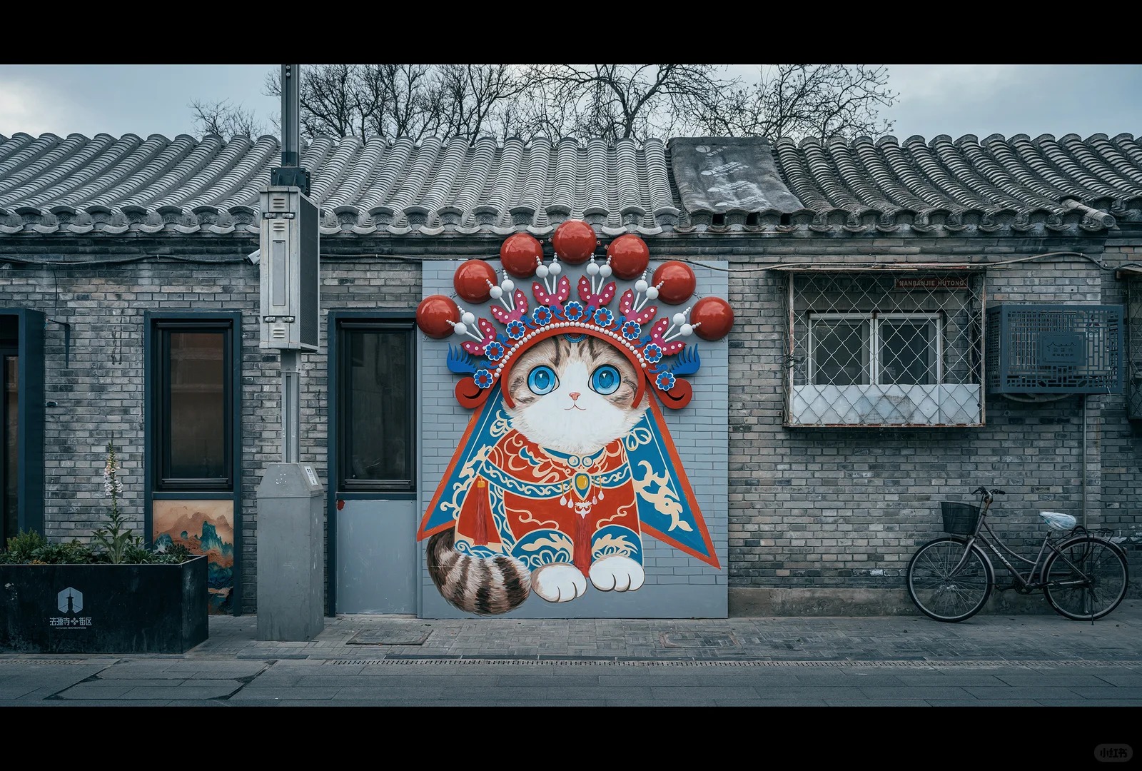 Colorful cat mural on a gray-brick hutong wall near Nanluoguxiang in Beijing.