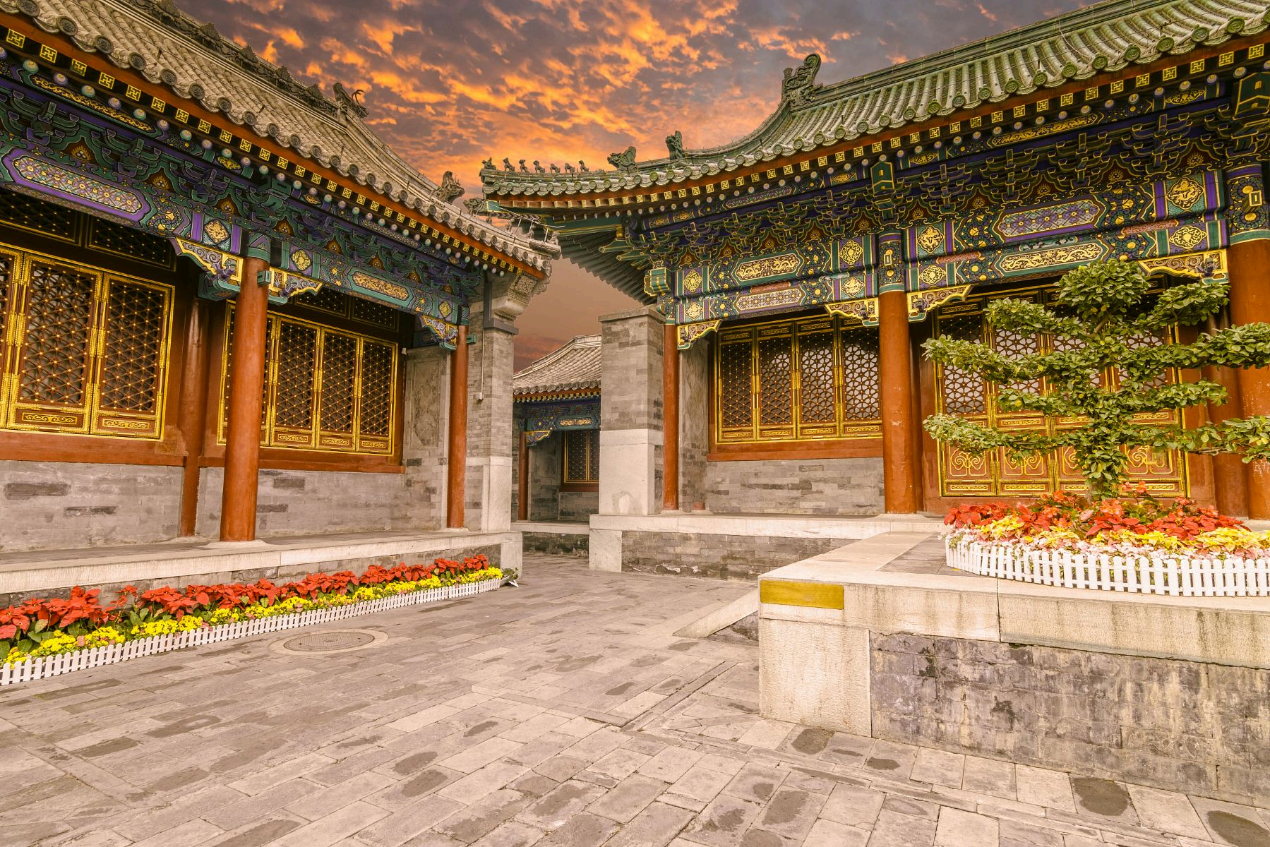 Ornate painted eaves and red columns in a Prince Gong's Mansion courtyard.