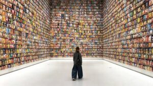 A visitor standing in front of a vast wall covered with thousands of snack packages at Changsha Snack Kingdom.
