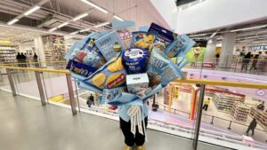 A visitor holding a large bouquet made from assorted packaged snacks inside Changsha Snack Kingdom.