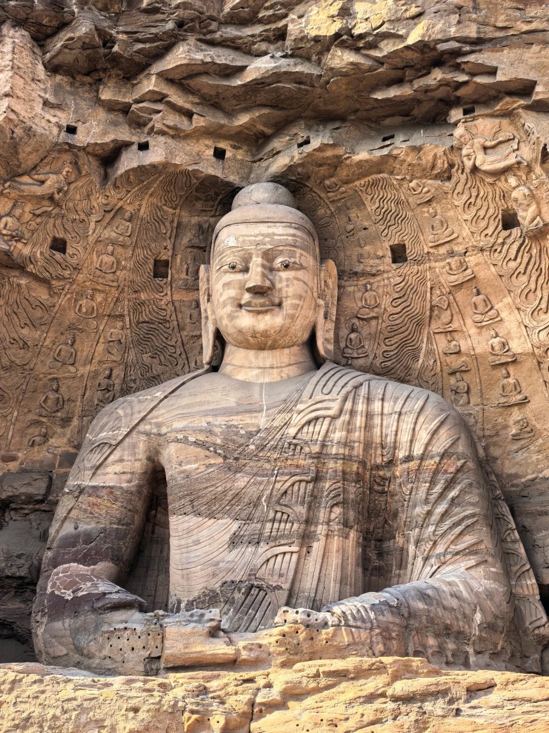 A monumental seated Buddha carved into sandstone at the Yungang Grottoes in Datong, Shanxi.