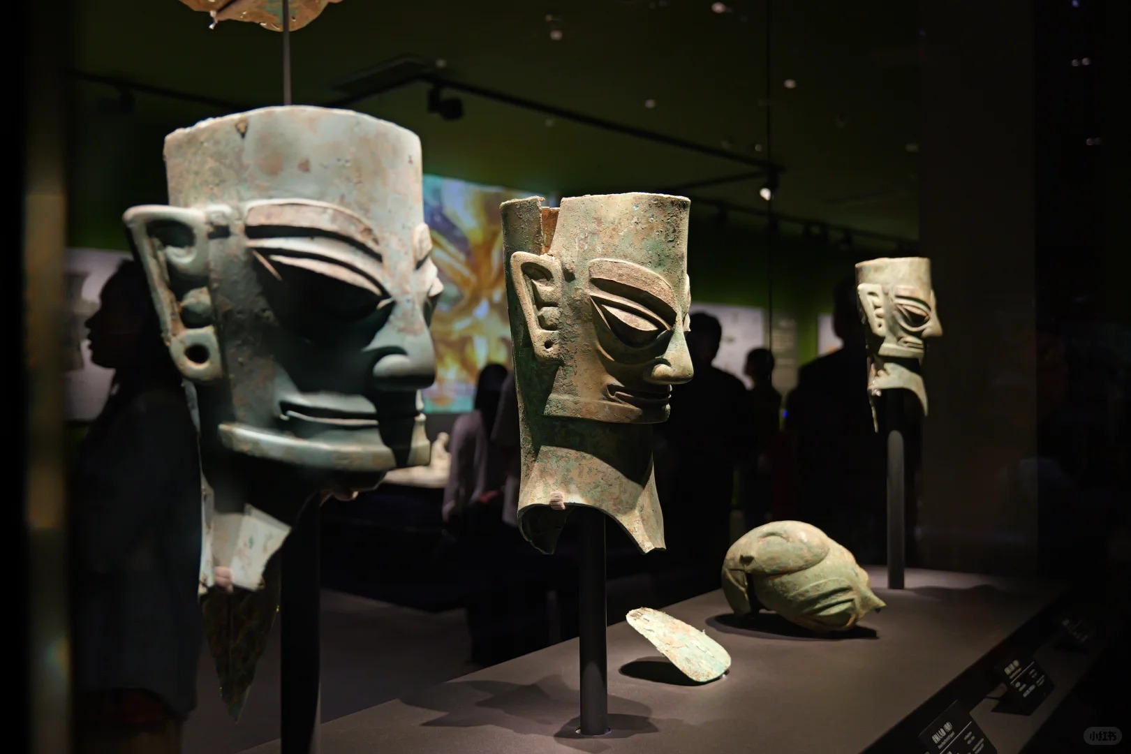 Ancient bronze masks displayed in a dark gallery at the Sanxingdui Museum in Sichuan.